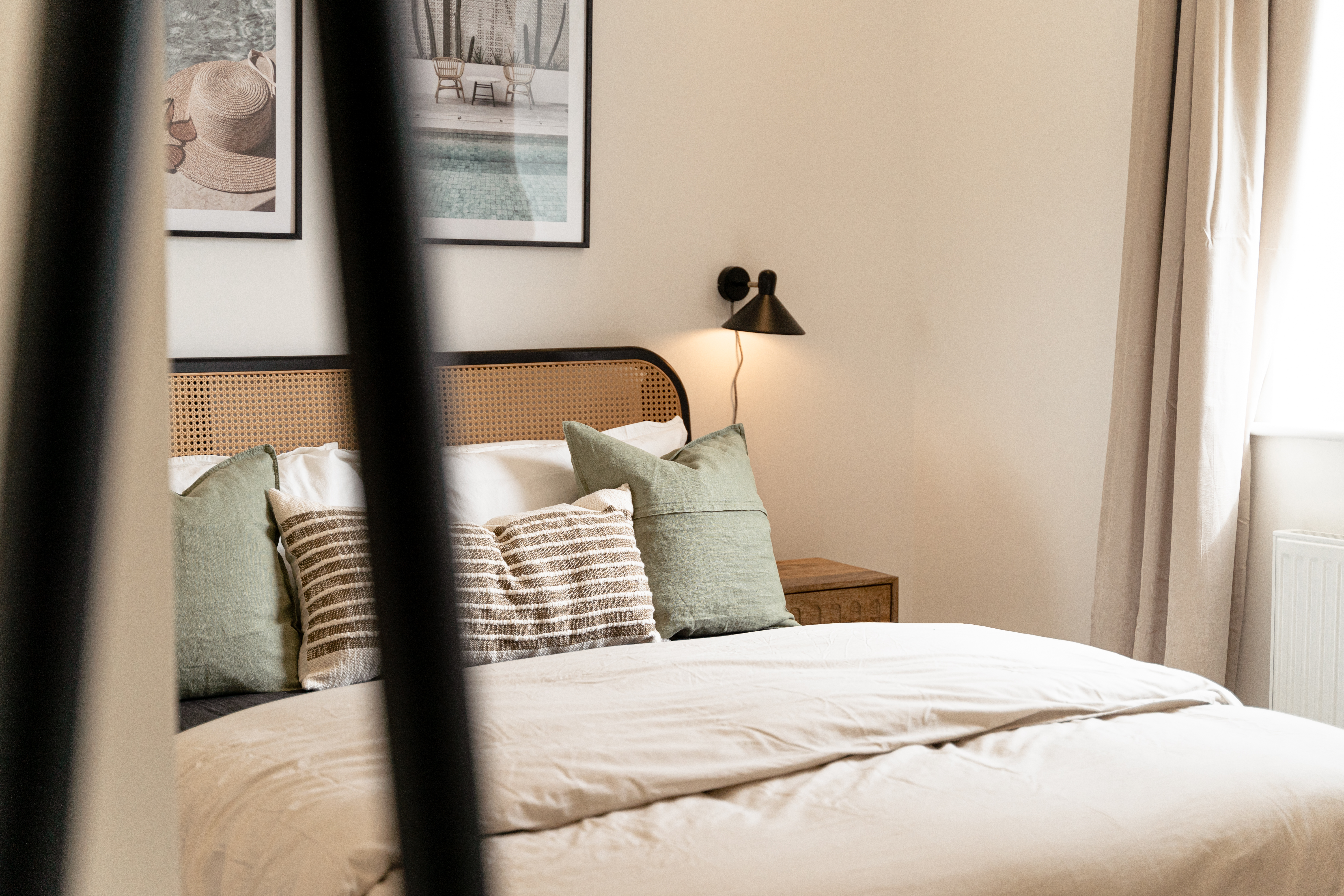 The bedroom — cane headboard and linen
